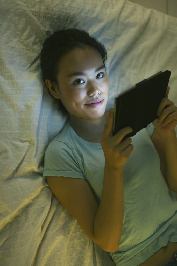 Smiling woman looking camera with digital tablet at home.