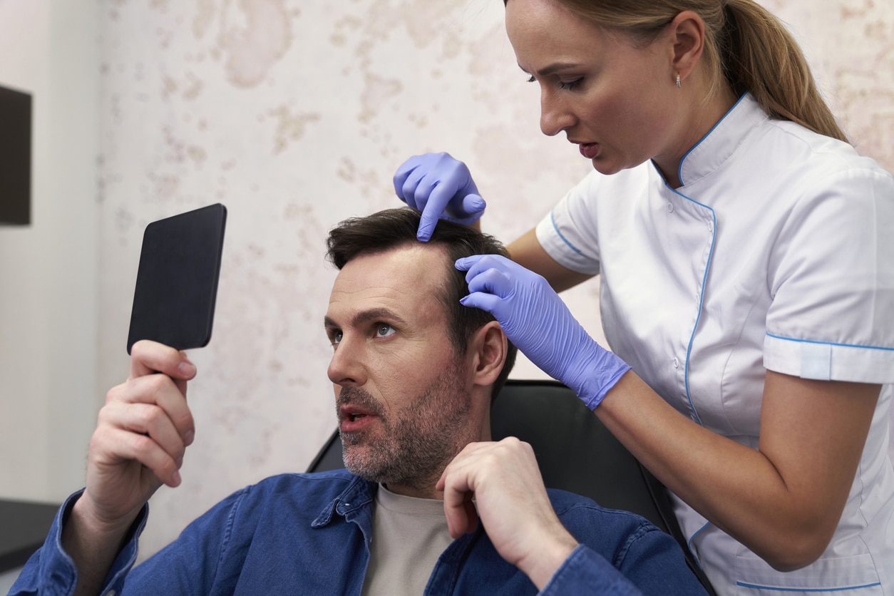 Man with early signs of hair loss at dermatologist